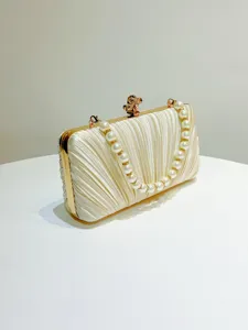 Pleated satin evening clutch detail showcasing gold metal frame and elegant pearl handle strap.