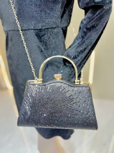 Zwarte strass avondtas detail met fonkelende kristallen, gouden handvat en ketting.