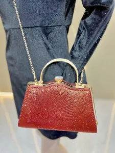 Rode strass avondtas detailweergave met sprankelende kristalafwerking en gouden metalen frame.