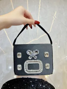 Detailansicht der schwarzen Satin-Abendtasche mit glitzerndem Kristallschmetterling und Strass.