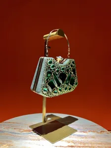 Exquisito bolso de noche de pedrería verde con detalles de cristal de lujo y asa dorada.