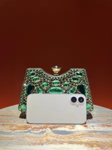 Primer plano de un lujoso bolso de mano tipo clutch de noche con brillante pedrería verde.