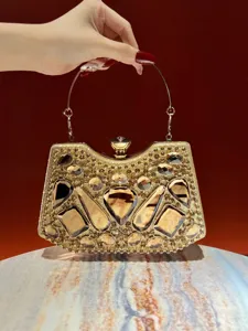 Lujoso bolso de mano de noche con pedrería dorada y detalles de cristales brillantes.