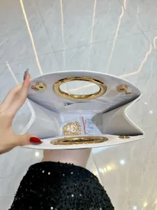 Vue détaillée de l'intérieur du sac de soirée blanc avec poignée ronde et chaîne dorée.