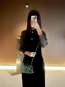 Detalle de bolso de mano con pedrería verde, elegante bolso de noche con correa de cadena.