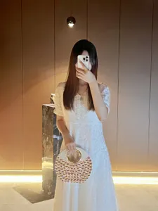 Sac de soirée rond pour femme avec poignée anneau métal et strass roses scintillants.