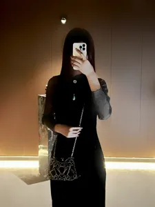 Exquisita cartera de mano de noche con pedrería brillante y elegantes detalles de cadena.