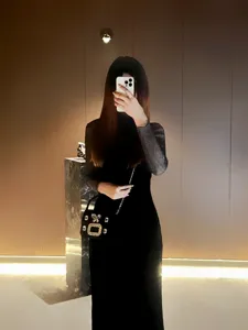 Detailansicht einer eleganten schwarzen Abendtasche mit funkelnder Strassschnalle und Kette.