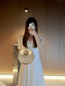 Vue détaillée du sac de soirée rond en strass étincelant avec poignée anneau en métal.