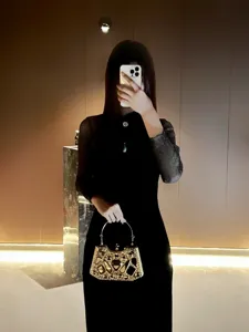Elegante bolso de noche tipo clutch con pedrería de cristal y asa de metal refinado.