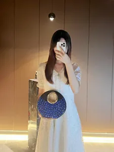 Élégant sac de soirée rond avec strass bleus et poignée anneau en métal pour fêtes.