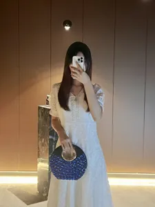 Chic sac de soirée rond avec paillettes bleues et poignée métallique pour femmes.