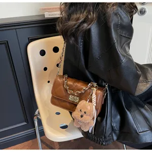 Brown quilted chain crossbody bag detail with cute plush bear pendant, elegant style accessory.