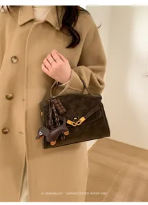 Klassieke retro bruine suède handtas met hanger, stijlvolle schoudertas en crossbodytas voor dames.