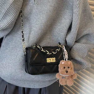 Women's black quilted shoulder bag with chain strap and cute bear charm for daily use