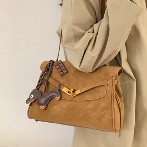 Retro bruine suède handtas voor dames, stijlvolle schoudertas met leuke hangers voor dagelijks.