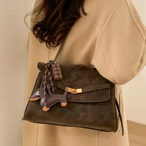 Vintage bruine suède schoudertas voor dames, elegante crossbody tas met leuke hanger.