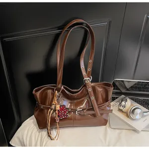 Elegante borsa a tracolla marrone in pelle verniciata da donna, con cinturini e ciondolo carino.