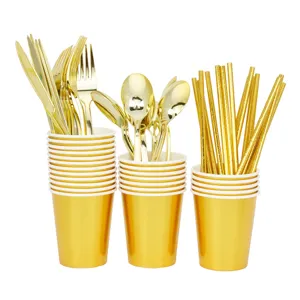 Detail view of disposable gold plastic tableware cups forks spoons and straws set closeup display
