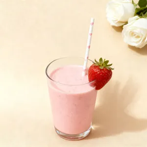 Detailed view of pink heart paper straw in a strawberry smoothie for romantic party drinks.