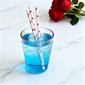 Red heart print paper straws detail shot, ideal for romantic Valentine party drink decoration.