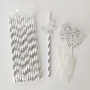 Primer plano de recortes de unicornio con purpurina plateada y pajitas de papel para fiestas.