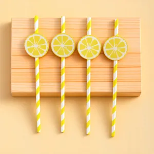 Detail shot of yellow striped paper straws with cute lemon slice cards for party decoration.