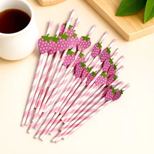 Pink striped paper straws with cute strawberry card decorations, perfect for party supplies.