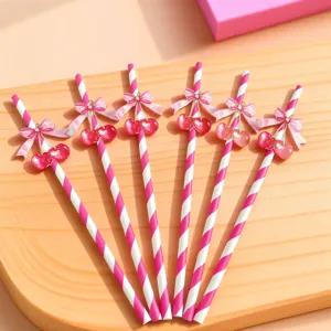 Pink striped paper drinking straws featuring cute cherry and bow decoration for party.