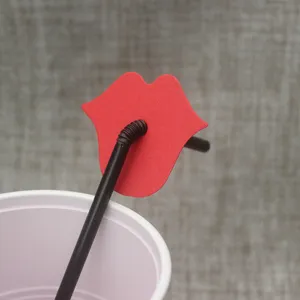 Creative party red lips decoration black plastic drinking straw close up detail view.