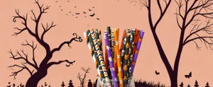Close-up view of Halloween paper straws featuring skull and pumpkin patterns in glass.