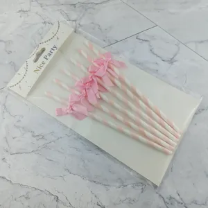 Disposable striped paper straws with pink bow decoration, perfect for party and cake decor.
