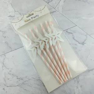Vue détaillée des pailles en papier rayées rose et blanc avec des étoiles pailletées.