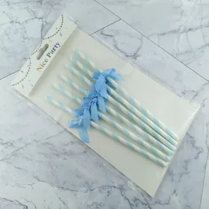 Close-up detail of blue and white striped paper straws with cute bows, packaged on card.