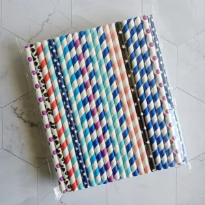 Detalle de pajitas de papel de colores con diseño de rayas y puntos para bebidas refrescantes.