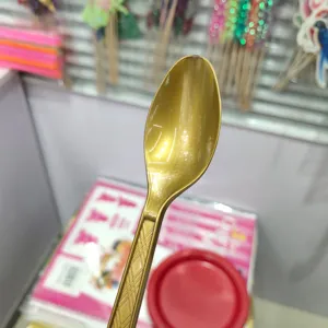 Disposable gold plastic spoons for birthday party table settings, elegant tableware.