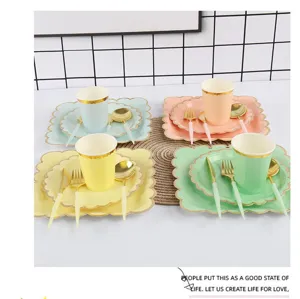 Detailed view of pastel disposable paper party tableware set with gold rim cups and plates.