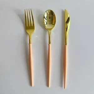 Détail rapproché de l'élégant ensemble de couverts en plastique doré et rose pour fête.