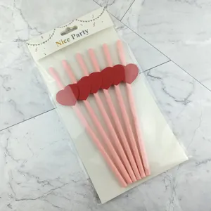 Disposable paper straws with heart decoration, pink party drinking straws set in packaging.