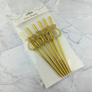 Vue détaillée de pailles en papier pailleté doré avec design de bague pour décoration de fête.