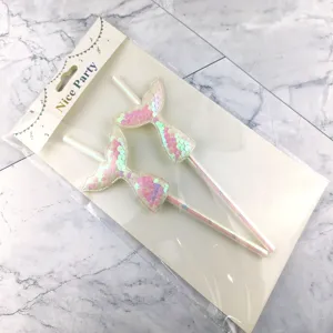 Close up detail of iridescent sequin mermaid tail paper straws for party cake decoration.