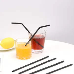 Gros plan détail de pailles à boire en plastique noir dans des verres avec du jus.