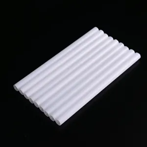 Close-up view of multiple clean white plastic hollow round tubes arranged neatly on a dark surface.