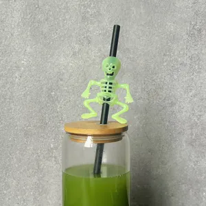 Halloween party straw decoration with fluorescent skeleton charm, fun drinkware accessory.