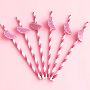 Primer plano detallado de pajitas de papel a rayas rosas y blancas con graciosos limones.