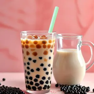Close-up detail of a bright green thick straw in a boba milk tea glass with tapioca pearls.