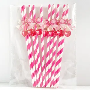 Pink striped paper straws with cute cherry and bow decorations, perfect for parties and events.