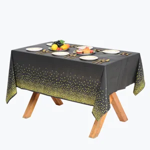 Nappe jetable rectangulaire à pois noirs et dorés pour décoration de table de fête d'anniversaire.