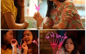 Novelty heart shaped double drinking straw detail showing couple using creative plastic art tubes.