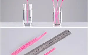 Close-up detail of pink disposable plastic drinking straws with flexible bendable sections.
